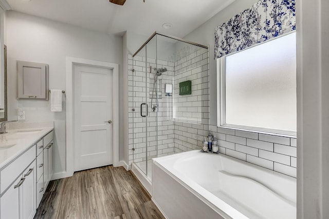 14302 Winema View Ln, Conroe, TX 77384 - full bathroom with a stall shower, a bath, double vanity, wood finished floors, and ceiling fan