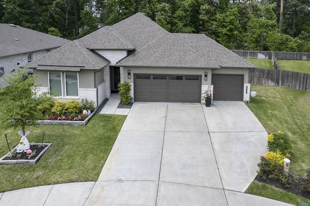 14302 Winema View Ln, Conroe, TX 77384 - view of front of house featuring a garage, roof with shingles, driveway, stucco siding, and brick siding