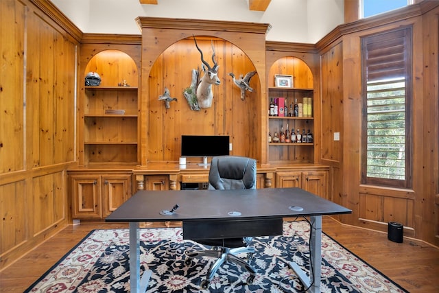 home office with wooden walls and wood finished floors