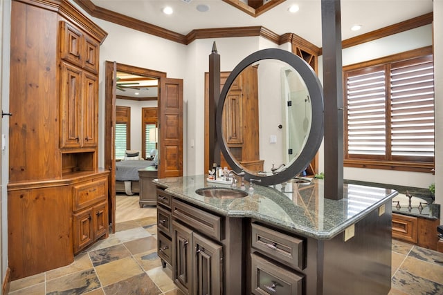 ensuite bathroom featuring ensuite bathroom, ornamental molding, stone tile floors, and recessed lighting