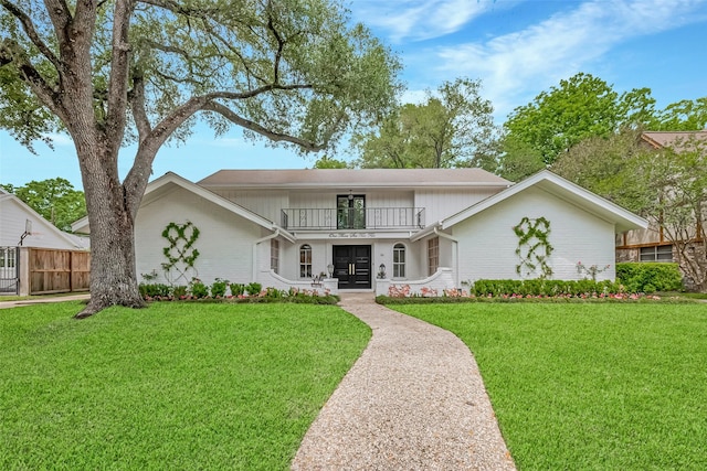 13622 Indian Creek Rd, Houston, TX 77079 - view of front of home featuring fence, a balcony, a front yard, covered porch, and french doors