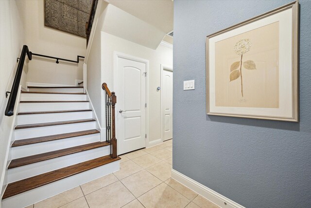 staircase with baseboards and tile patterned flooring