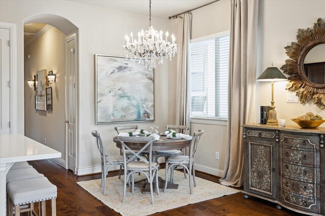 dining area with arched walkways, a notable chandelier, baseboards, and dark wood-style flooring