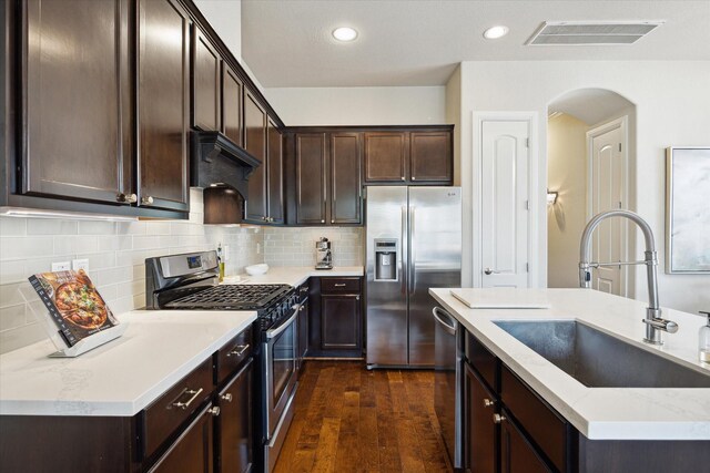 kitchen with dark brown cabinets, visible vents, a sink, and appliances with stainless steel finishes