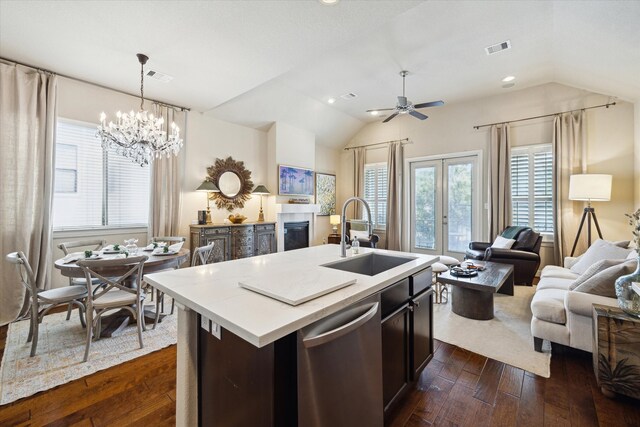 kitchen featuring dishwasher, lofted ceiling, open floor plan, and a sink