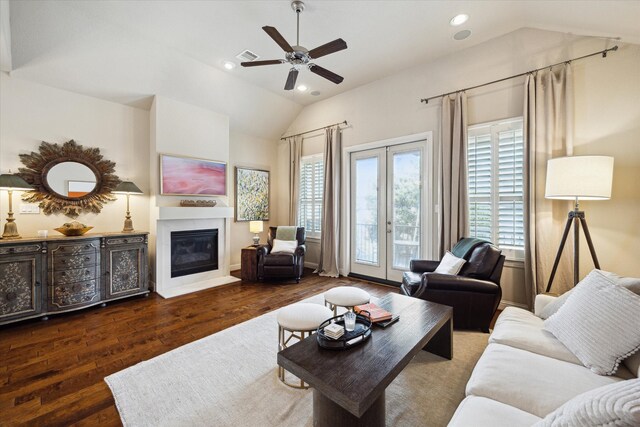 living area featuring french doors, vaulted ceiling, a glass covered fireplace, wood finished floors, and ceiling fan