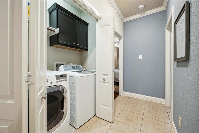 washroom featuring light tile patterned flooring, washing machine and dryer, baseboards, cabinet space, and crown molding