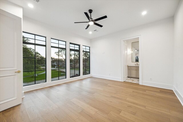 empty room featuring light wood-style flooring, a wealth of natural light, and ceiling fan