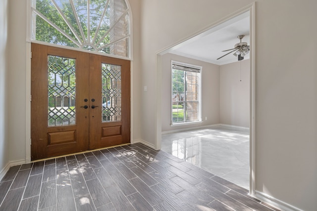 foyer featuring crown molding, wood finish floors, baseboards, and french doors