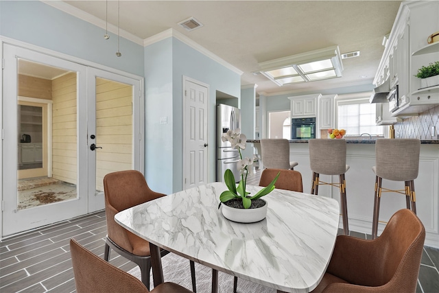 dining space with ornamental molding, french doors, and visible vents