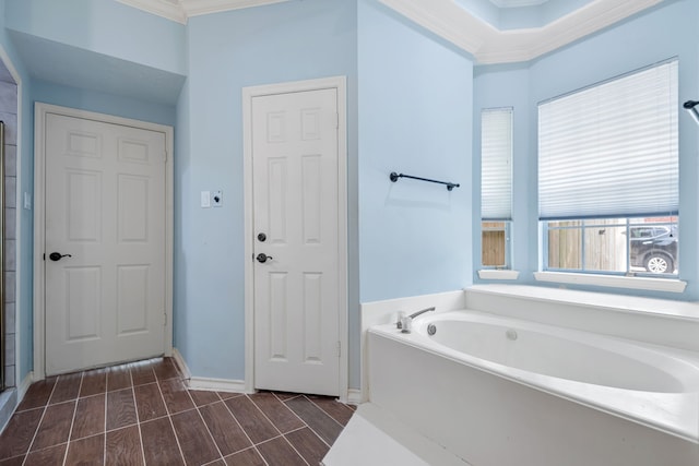 bathroom with wood tiled floor, a bath, crown molding, baseboards, and a shower with door