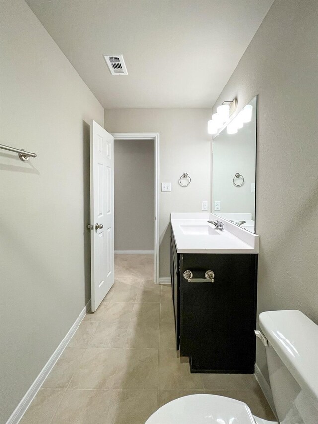 bathroom with toilet, baseboards, visible vents, and vanity