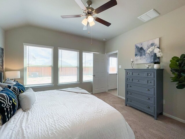 bedroom with a ceiling fan, visible vents, baseboards, lofted ceiling, and light carpet