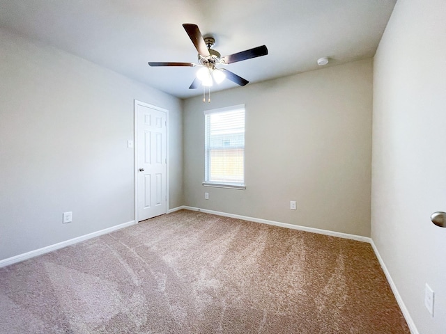 carpeted spare room with baseboards and ceiling fan
