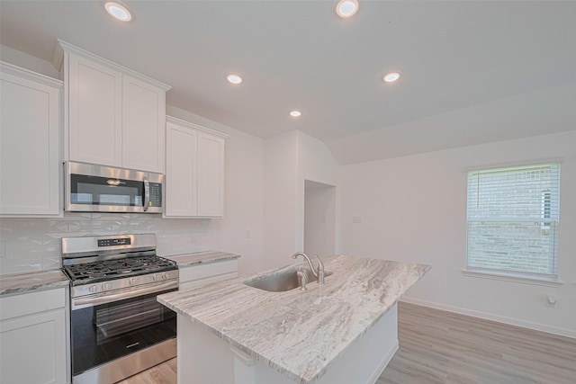 17722 Pamukkale Pl, Tomball, TX 77377 - kitchen with stainless steel appliances, a sink, backsplash, light wood-type flooring, and white cabinetry