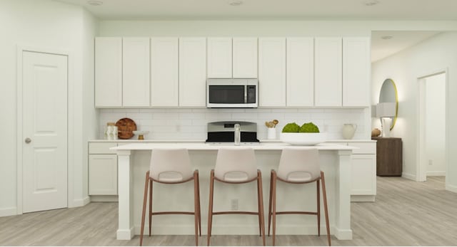 kitchen featuring stove, light wood-style floors, tasteful backsplash, and white microwave
