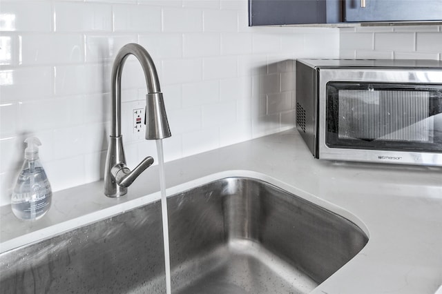 6300 Seawall Blvd Unit 3225, Galveston, TX 77551 - room details featuring light stone countertops, a sink, stainless steel microwave, and tasteful backsplash