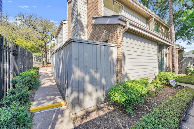 view of side of property with fence and brick siding