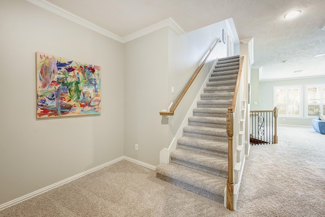 staircase featuring baseboards, ornamental molding, and carpet flooring