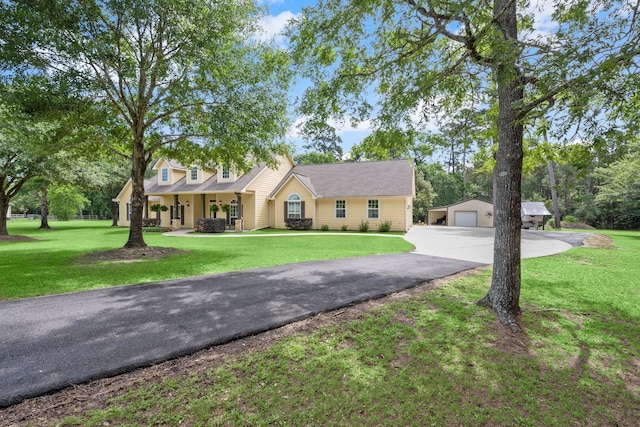 cape cod home with covered porch, an outbuilding, a front lawn, and a garage