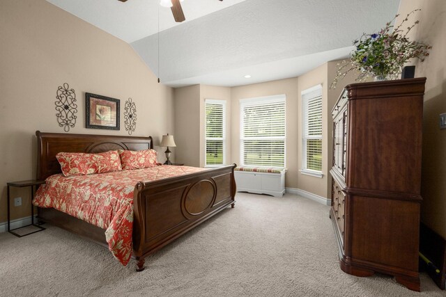 bedroom featuring light carpet, baseboards, a ceiling fan, and lofted ceiling