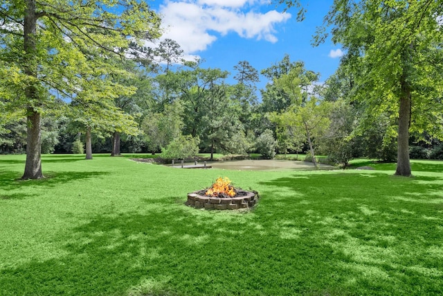 view of home's community featuring a fire pit and a yard