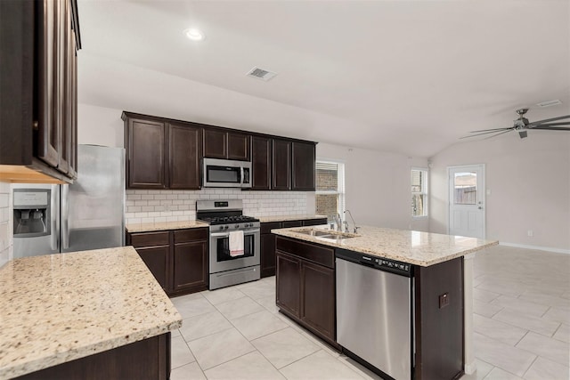 kitchen featuring stainless steel appliances, visible vents, a sink, light tile patterned flooring, and decorative backsplash