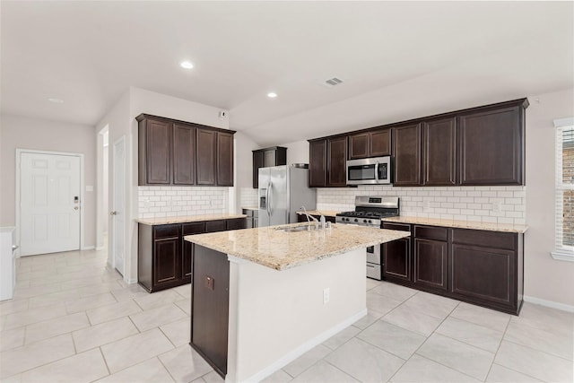 kitchen with tasteful backsplash, dark brown cabinets, stainless steel appliances, and light tile patterned floors