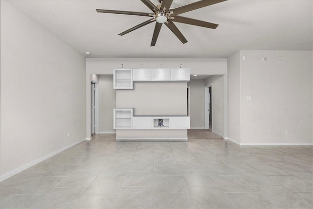 unfurnished living room featuring baseboards and ceiling fan