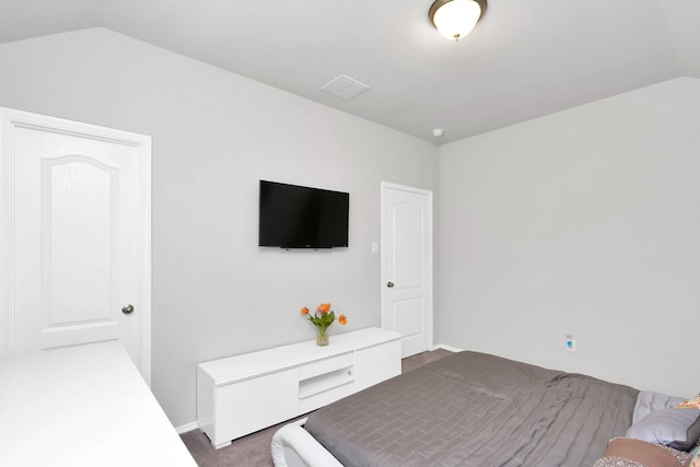 bedroom featuring lofted ceiling and dark carpet