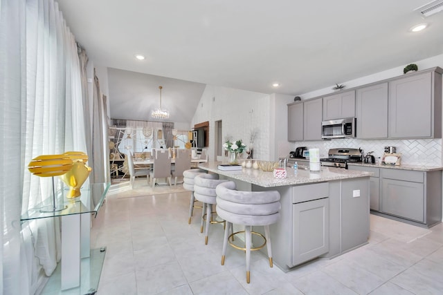 kitchen featuring lofted ceiling, visible vents, appliances with stainless steel finishes, and gray cabinetry