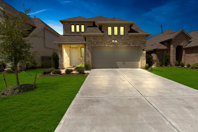 view of front facade with an attached garage, driveway, brick siding, and a front yard