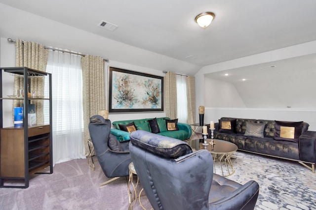 carpeted living room featuring vaulted ceiling and visible vents