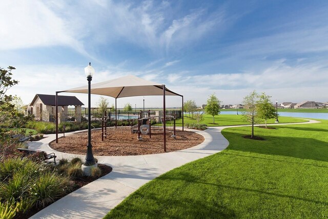 view of home's community with a yard, a water view, and playground community