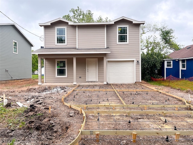 view of front of property featuring an attached garage, a porch, and a vegetable garden