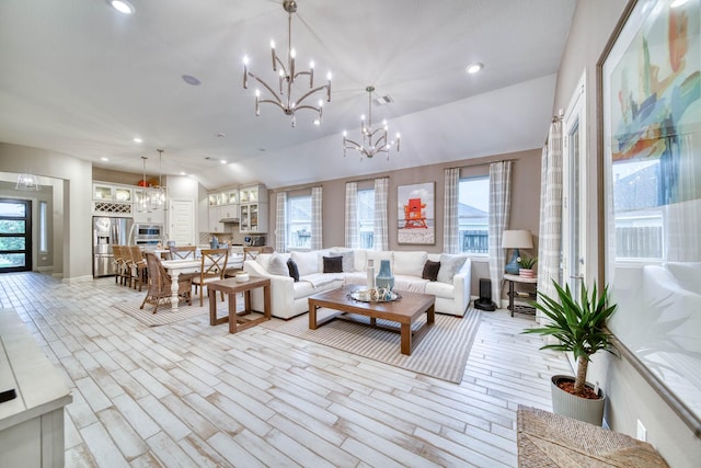 living area with an inviting chandelier, light wood finished floors, and plenty of natural light