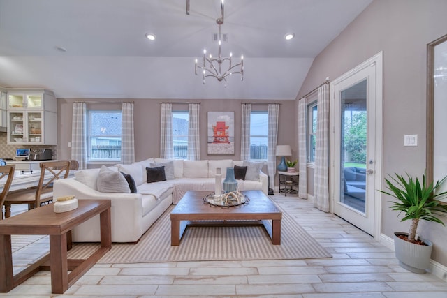 living room featuring visible vents, vaulted ceiling, an inviting chandelier, and plenty of natural light