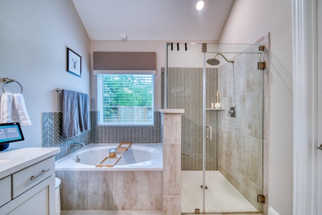 bathroom featuring a shower stall, a garden tub, and vanity
