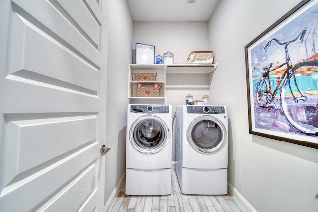 laundry room featuring light wood-style floors, washer and clothes dryer, laundry area, and baseboards