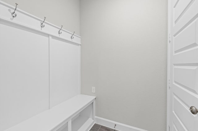 mudroom featuring baseboards and dark tile patterned flooring