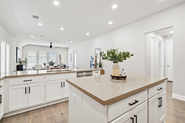 kitchen with visible vents, a sink, recessed lighting, and a kitchen island