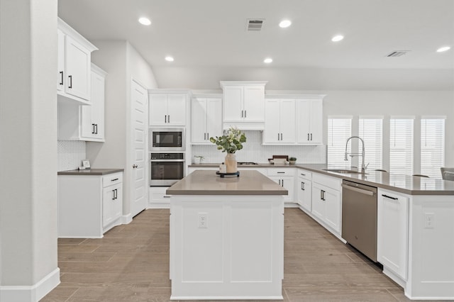 20806 Gray Percheron Ln, Tomball, TX 77377 - kitchen featuring appliances with stainless steel finishes, a kitchen island, decorative backsplash, a peninsula, and recessed lighting