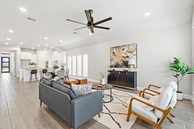 living area featuring recessed lighting, light wood finished floors, visible vents, a ceiling fan, and baseboards