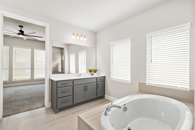 full bath with a bath, vanity, a wealth of natural light, and ceiling fan