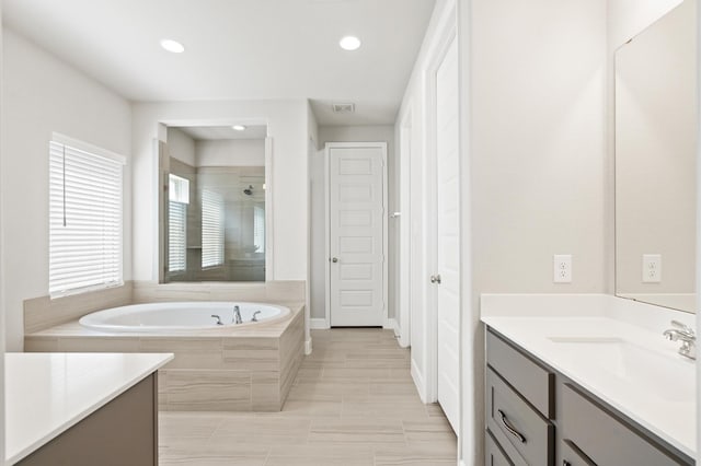 full bathroom with recessed lighting, a tile shower, a garden tub, and vanity