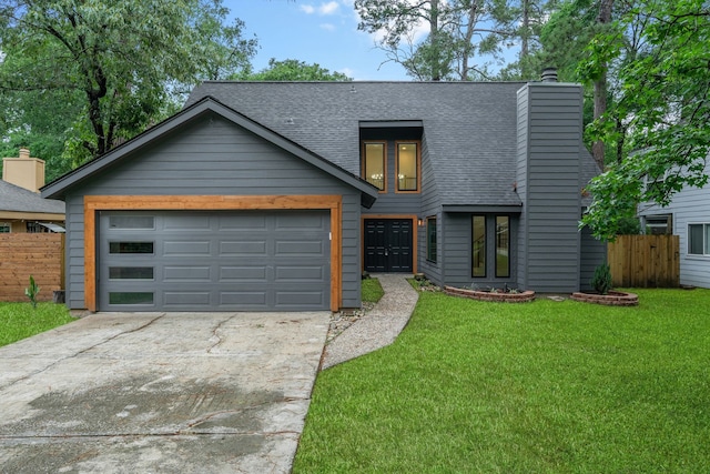 view of front of home with fence, driveway, roof with shingles, and a front yard