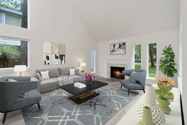 living area featuring high vaulted ceiling, a lit fireplace, and wood finished floors