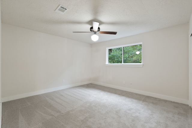 empty room featuring carpet floors, ceiling fan, baseboards, and visible vents
