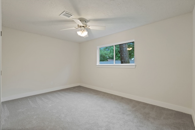 spare room with carpet floors, baseboards, and visible vents