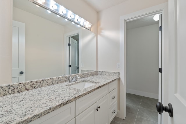 bathroom featuring vanity, baseboards, and tile patterned floors